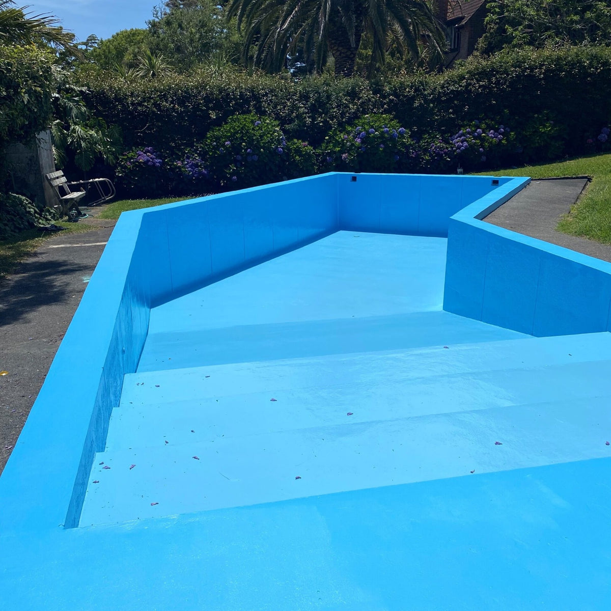 Freshly coated backyard pool ready to fill